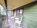 Cottage's front porch with rocking chairs and green siding at 1541 Harbin Sw Rd, Atlanta, GA 30311
