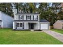 Front exterior view of a two-story home with a lush green lawn and driveway at 1344 Mill Lake Cir, Stone Mountain, GA 30088