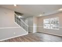 Living room featuring wood-look flooring, a staircase, and large window at 1344 Mill Lake Cir, Stone Mountain, GA 30088