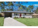 Front view of a ranch home with a red door and driveway at 1933 Glen Echo Dr, Decatur, GA 30032