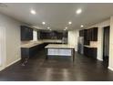 Modern kitchen with dark wood cabinets, an island, and stainless steel appliances at 566 Mariposa Ln, Mcdonough, GA 30253