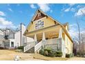 Inviting yellow craftsman-style home with a large front porch and stone accents at 1351 Lakeview East Dr, Atlanta, GA 30316