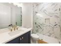 Modern bathroom with marble shower, navy vanity, and gold fixtures at 6214 Talmadge Nw Way, Acworth, GA 30101