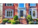 Front entrance with brick facade, black door, and landscaping at 1081 Talon Trce, Lawrenceville, GA 30043