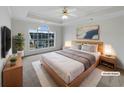 Virtually staged main bedroom with a large window, plush carpeting, and a ceiling fan at 1472 Buckingham Pl, Stockbridge, GA 30281