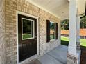 Covered front porch with dark front door, sidelights, and white columns at 5110 Black Bear Trl, Douglasville, GA 30135