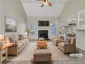 Virtually staged living room featuring a cozy fireplace, vaulted ceiling, and ample natural light at 125 Cedars Glen Cir, Villa Rica, GA 30180