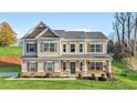 Two-story house with a beige facade, brick accents, and a landscaped lawn at 200 Cherokee Reserve Cir, Canton, GA 30115