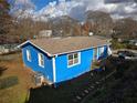Elevated view of a blue house with a fenced backyard, AC unit, and surrounding trees at 149 Bixby Se Ter, Atlanta, GA 30317