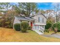Tan house with red door, landscaping, and white railing at 3972 Glenwood Downs Ln, Decatur, GA 30035