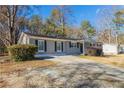 Ranch house with gray brick exterior and a large yard at 8661 Chestnut Ln, Lithia Springs, GA 30122