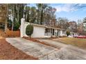 White brick ranch-style home with a concrete driveway and fenced backyard at 2590 Rolling View Se Dr, Smyrna, GA 30080