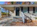 Front view of a tan brick ranch home with a black front door and white railing at 2329 Meadowlane Sw Dr, Atlanta, GA 30311
