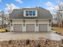 Three-car garage with dormers, light beige doors, and a white exterior at 2216A E Cherokee Dr, Woodstock, GA 30115