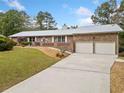 Brick ranch house with a metal roof, two-car garage, and a manicured lawn at 7312 Melrose Ct, Villa Rica, GA 30180