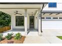 Covered front porch with gray door, ceiling fan, and sidelights at 3208 Altacrest Dr, Scottdale, GA 30079