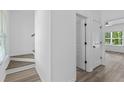 Bright hallway with stairs, wood-look floors, and doors to other rooms at 3328 Pepperpike Ct, Loganville, GA 30052