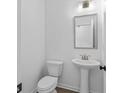 Small, clean powder room with pedestal sink and white toilet at 3328 Pepperpike Ct, Loganville, GA 30052