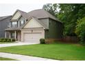 Green and beige two-story house with a two-car garage and a spacious lawn at 1180 Hartwell Rd, Locust Grove, GA 30248