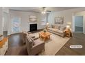 Virtually staged living room with a fireplace and hardwood floors at 607 Stream Ct, Fairburn, GA 30213