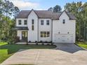 Two-story farmhouse with white siding, gray doors, and a large driveway at 2587 Kingsley Ne Dr, Marietta, GA 30062