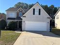 Two-story house with a large white garage door and a well-maintained lawn at 315 Horseshoe Bnd, Riverdale, GA 30274