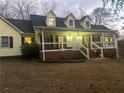 Inviting two-story home, featuring a wraparound porch and charming landscaping at 1060 River Cove Rd, Social Circle, GA 30025