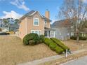 Two-story house with light brown siding, stone accents, and a landscaped front yard at 3050 Raven Trc, Fairburn, GA 30213