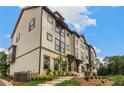 Beige townhouses with dark brown accents and landscaping; view of stairs and AC units at 1088 Battery Park Rd, Decatur, GA 30033
