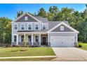 Two-story home with gray siding, stone accents, and a two-car garage at 714 Ocmulgee Xing, Locust Grove, GA 30248