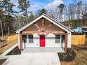 White farmhouse with red door and a large driveway at 860 Gardner Sw St, Austell, GA 30168