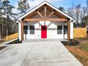 White farmhouse exterior with a red door, wood beams, and a covered porch at 860 Gardner Sw St, Austell, GA 30168