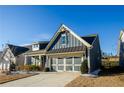 Two-story home with gray siding, a charming front porch, and a two-car garage at 511 Forest Ln, Canton, GA 30114