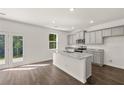 Modern kitchen with gray cabinets, granite counters, and an island at 145 Bonito Trl, Covington, GA 30016