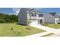 Two-story house with gray siding, brick accents, and a two-car garage at 130 Bonito Trl, Covington, GA 30016