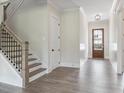 Bright and airy foyer with hardwood floors and a staircase with iron railings at 3325 Hillshire Dr, Cumming, GA 30028