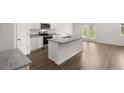 Modern kitchen with island, stainless steel appliances, and hardwood floors at 120 Bonito Trl, Covington, GA 30016