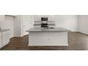 Modern kitchen with island, granite countertops, and hardwood floors at 120 Bonito Trl, Covington, GA 30016