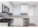 Renovated kitchen, granite countertops, stainless steel appliances, and gray tile backsplash at 2452 Semmes St, Atlanta, GA 30344