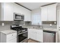 Renovated kitchen, granite countertops, stainless steel appliances, and gray tile backsplash at 2452 Semmes St, Atlanta, GA 30344
