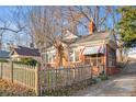 Brick home with a charming front porch, picket fence, and driveway at 1015 Deckner Sw Ave, Atlanta, GA 30310