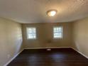 Well-lit bedroom featuring dark laminate flooring and two windows at 4195 Blanton Sw Ave, Atlanta, GA 30331