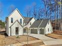 Two-story white brick house with gray roof and attached three-car garage at 120 Thome Dr, Alpharetta, GA 30022