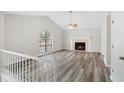 Living room with fireplace, vaulted ceiling, and wood-look flooring at 6764 Creek Valley Way, Douglasville, GA 30134