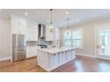 Modern kitchen with white cabinets, large island, stainless steel appliances, and hardwood floors at 324 Concord St, Alpharetta, GA 30009