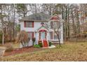Two-story house with red accents, driveway, and mature trees in the yard at 308 Mainsail Ln, Woodstock, GA 30189
