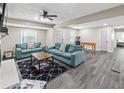 Open living area with teal sofas, wood-look floors, and a fireplace at 6623 Stark Ct, Riverdale, GA 30274