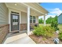 Covered front porch with seating area and brick columns at 4929 Calgary Dr, Douglasville, GA 30135
