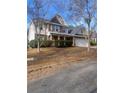 Two-story house with stone and shingle accents, a large driveway and manicured landscaping at 539 Greyhawk Way, Fairburn, GA 30213