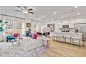 Open living space with white sectional sofa, kitchen island, and hardwood floors at 223 Sanctuary Dr, Mcdonough, GA 30253